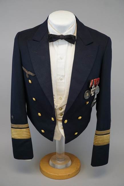 A suit with pins on the sleeve

Description automatically generated with medium confidence
