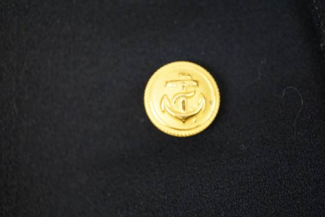 A gold coin with an anchor on it

Description automatically generated