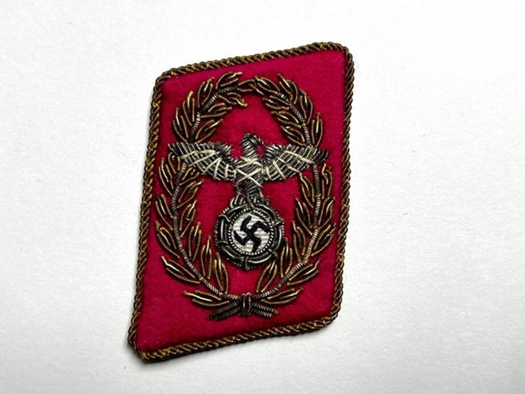 A red patch with a bird and a swastika

Description automatically generated