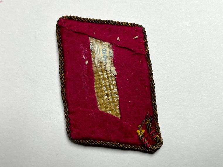 A red fabric with gold trim

Description automatically generated