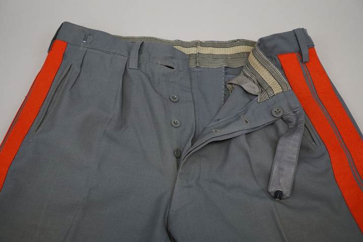 A pair of grey pants with orange stripes

Description automatically generated