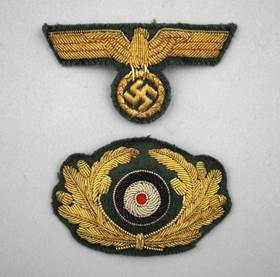 A gold eagle patch on a grey background

Description automatically generated